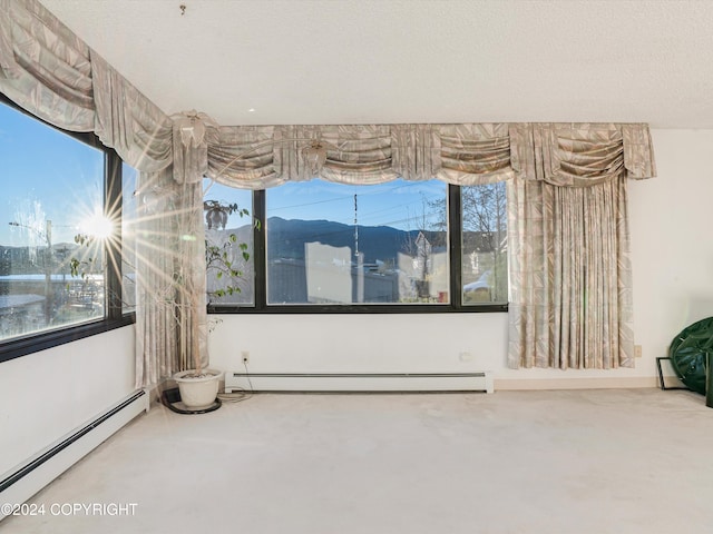 spare room featuring carpet floors, a textured ceiling, and a baseboard heating unit