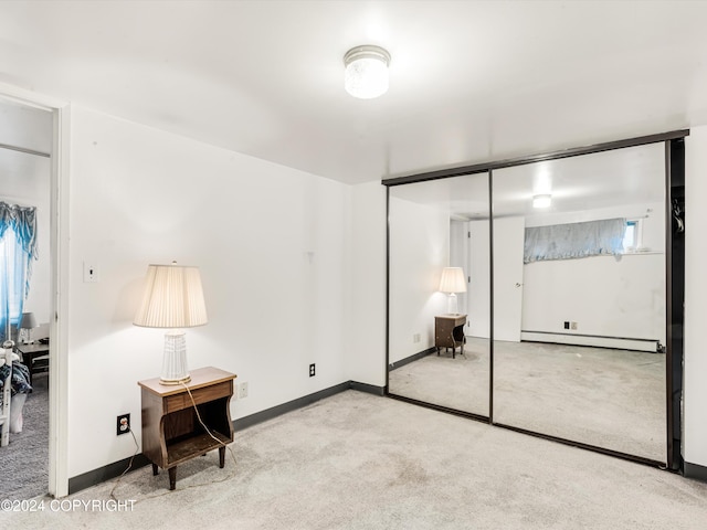 bedroom featuring multiple windows, light colored carpet, a closet, and a baseboard heating unit