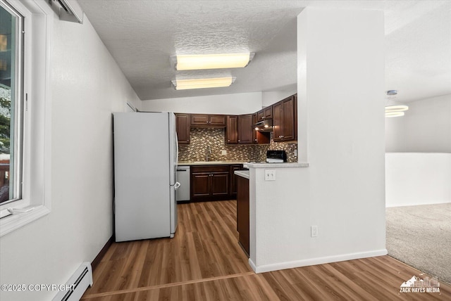 kitchen featuring light countertops, freestanding refrigerator, stainless steel dishwasher, stove, and a baseboard radiator