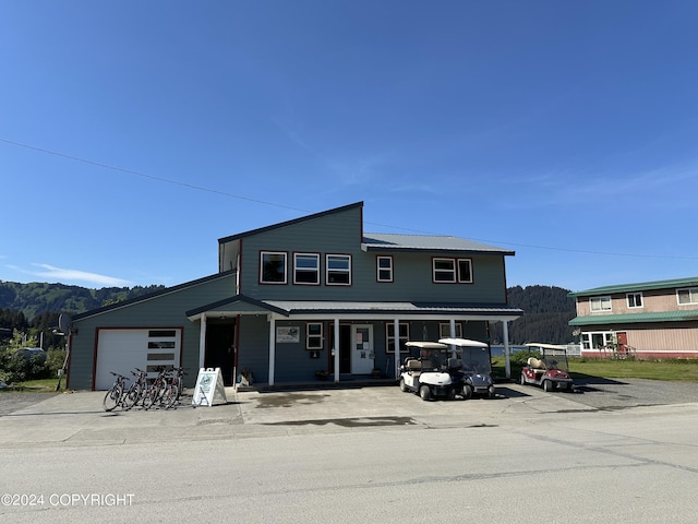 view of front of house featuring a mountain view, covered porch, and a garage