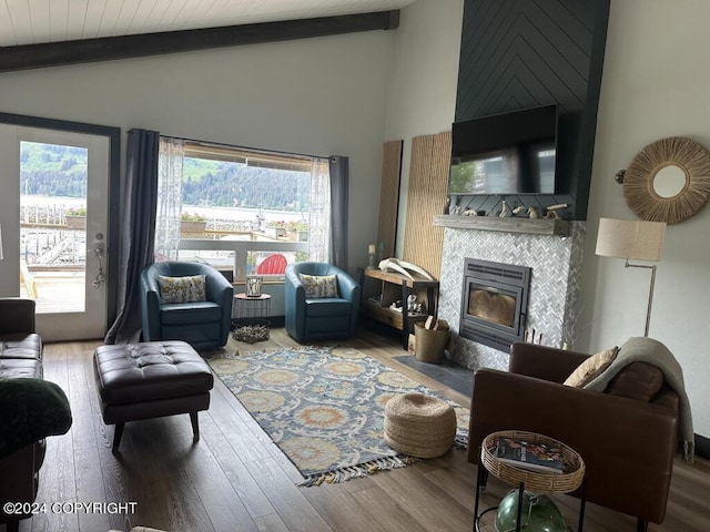 living room with hardwood / wood-style flooring, lofted ceiling with beams, and a fireplace