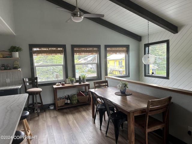 dining room featuring vaulted ceiling with beams, ceiling fan, a wealth of natural light, and light hardwood / wood-style flooring