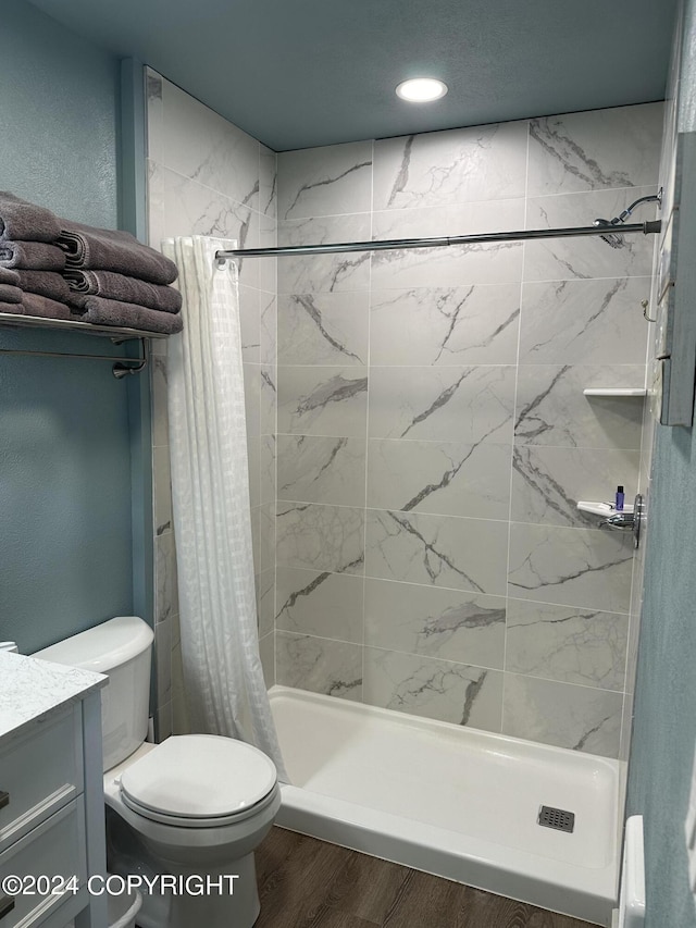 bathroom with a shower with curtain, toilet, wood-type flooring, and vanity