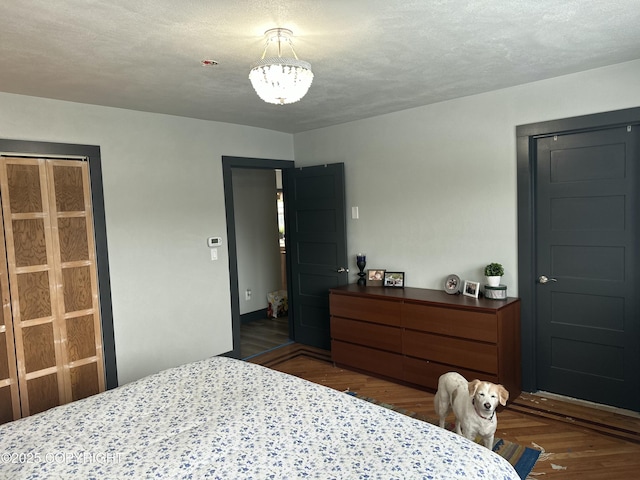 251 Main St, Seldovia, AK 99663 - bedroom with a textured ceiling, a notable chandelier, dark wood-style floors, and baseboards
