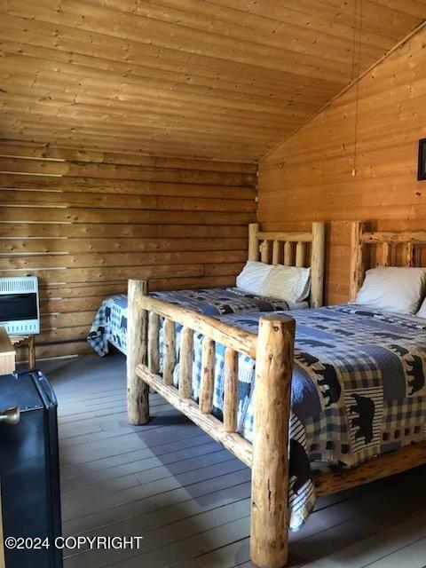 28160 Chestes St, Ninilchik, AK 99556 - bedroom with vaulted ceiling, heating unit, wood-type flooring, wooden ceiling, and wooden walls