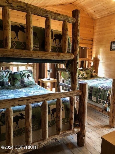 28160 Chestes St, Ninilchik, AK 99556 - bedroom featuring wood-type flooring, vaulted ceiling, wooden walls, and wooden ceiling