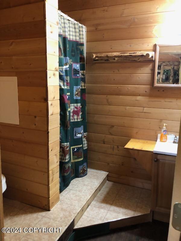 28160 Chestes St, Ninilchik, AK 99556 - full bath with wooden walls, a shower with curtain, and tile patterned floors