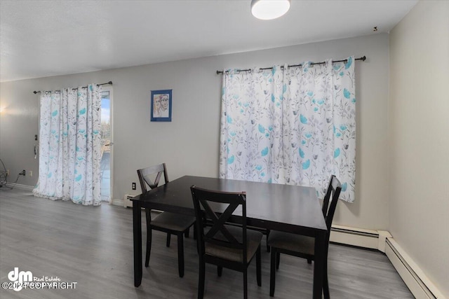 3591 Lynn Dr # 1, Anchorage, AK 99508 - dining room featuring wood finished floors, a baseboard radiator, and baseboards