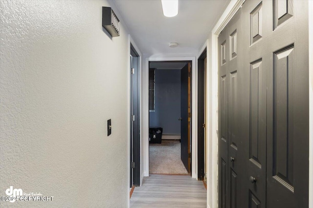 3591 Lynn Dr # 1, Anchorage, AK 99508 - corridor with light wood-style floors, a baseboard heating unit, baseboards, and a textured wall