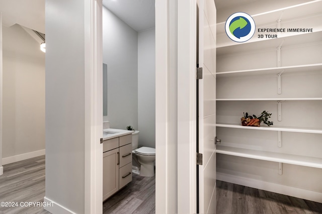 bathroom with hardwood / wood-style flooring, vanity, and toilet