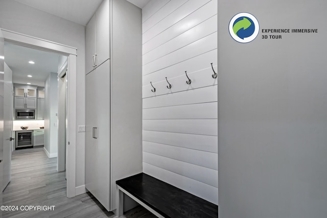 mudroom with beverage cooler and light hardwood / wood-style flooring