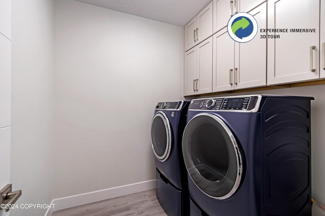 laundry room with cabinets, light hardwood / wood-style flooring, and washer and clothes dryer