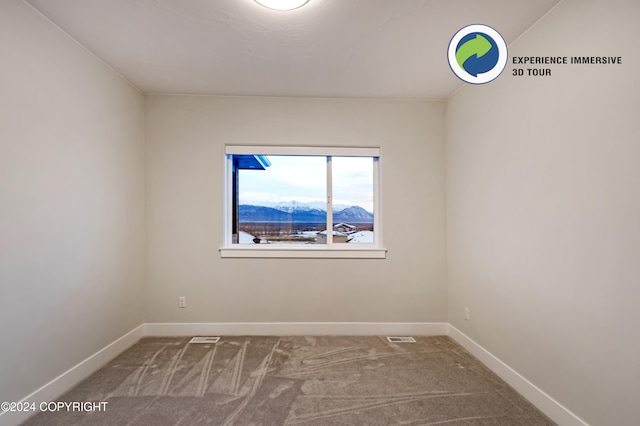 carpeted spare room featuring a mountain view