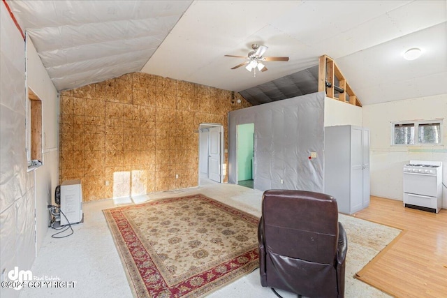 office with ceiling fan, tile walls, vaulted ceiling, and light hardwood / wood-style floors