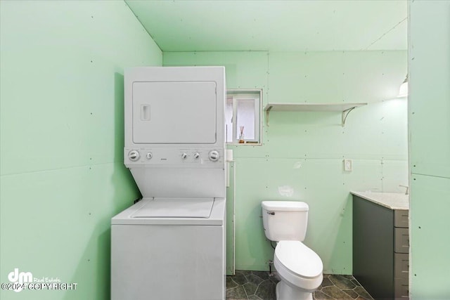 bathroom featuring toilet and stacked washer and clothes dryer