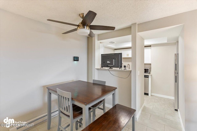 dining room with ceiling fan, a textured ceiling, and light tile patterned flooring