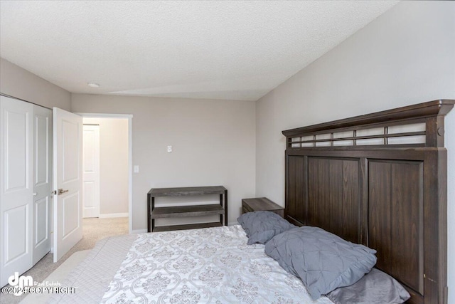 bedroom featuring light carpet, a textured ceiling, and a closet