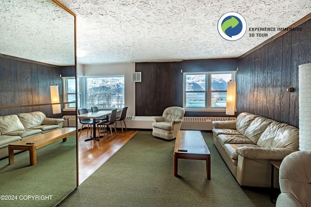 living room with wood-type flooring, a textured ceiling, ornamental molding, and wood walls