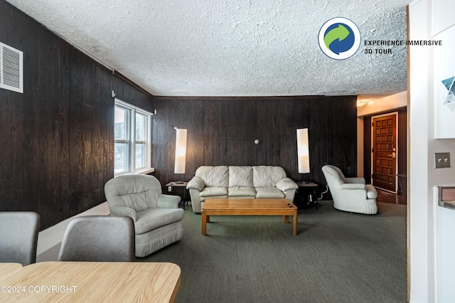 carpeted living room with wooden walls and a textured ceiling