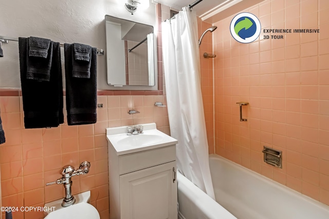 bathroom with vanity, shower / bath combo, and tile walls