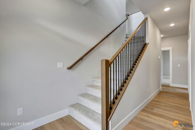 stairs featuring hardwood / wood-style floors