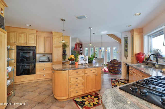 kitchen featuring sink, black appliances, light brown cabinetry, and plenty of natural light