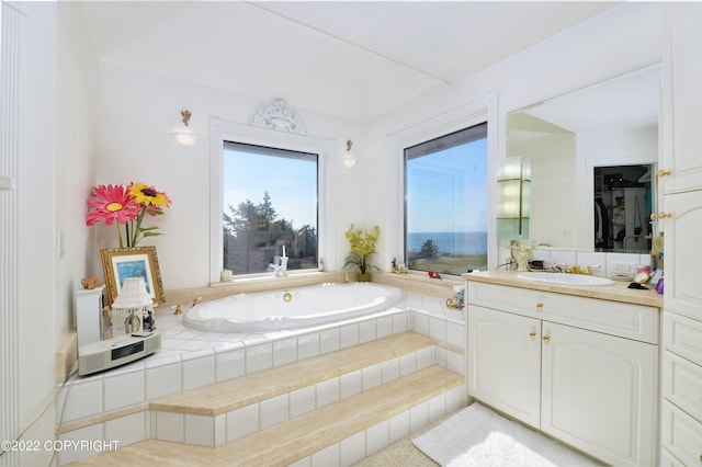 bathroom featuring vanity and tiled bath