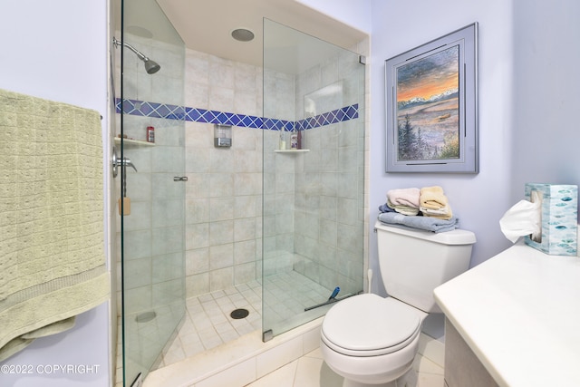 bathroom with vanity, toilet, tile patterned floors, and a shower with shower door