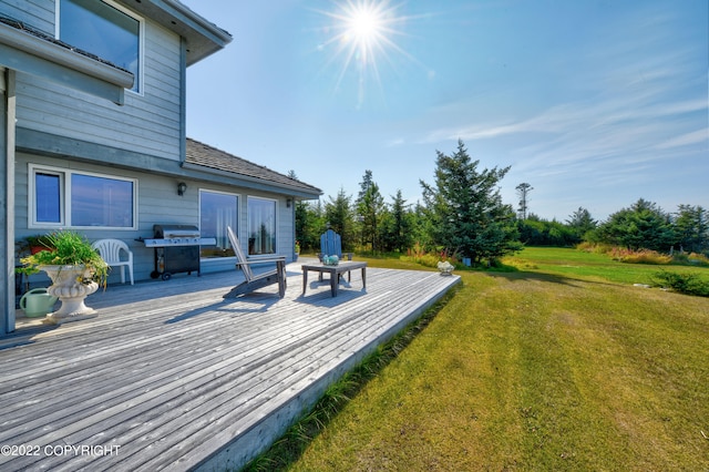 wooden terrace featuring a yard and area for grilling