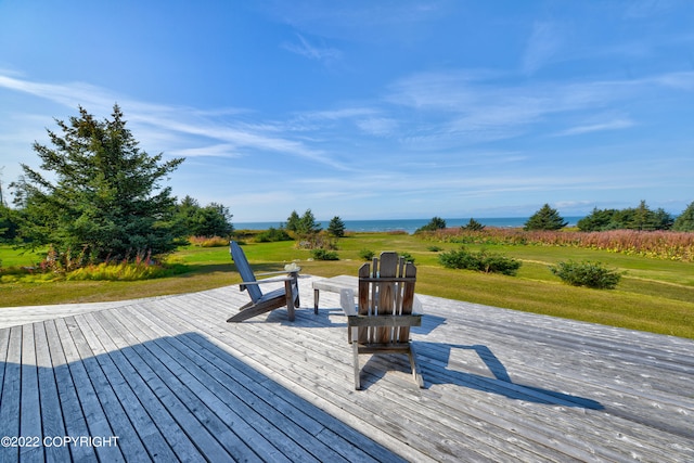 wooden terrace with a lawn and a water view