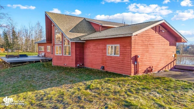 view of home's exterior with a wooden deck and a yard