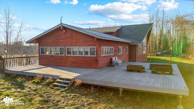 back of house with a wooden deck and a lawn