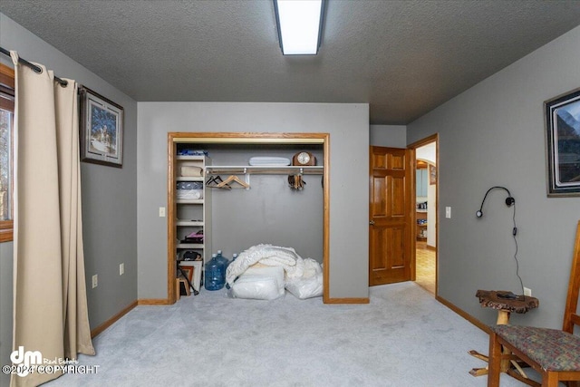 bedroom with a textured ceiling, light carpet, and a closet