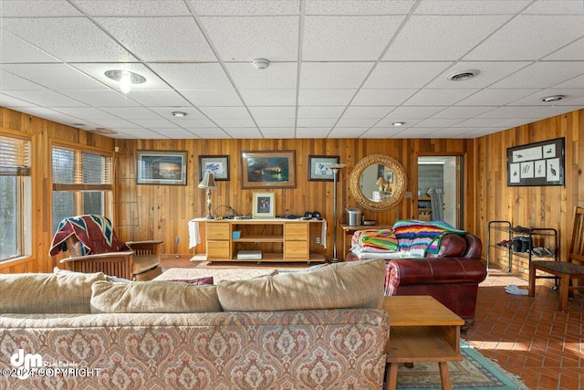 living room with wood walls and a drop ceiling