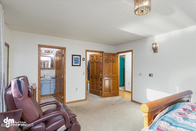 bedroom featuring connected bathroom, light carpet, and a textured ceiling