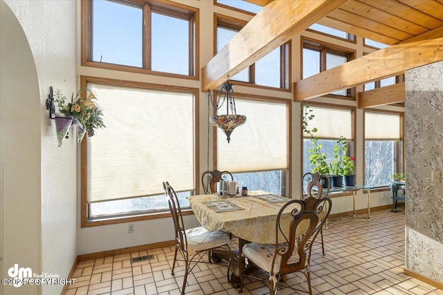 dining room with lofted ceiling with beams and plenty of natural light