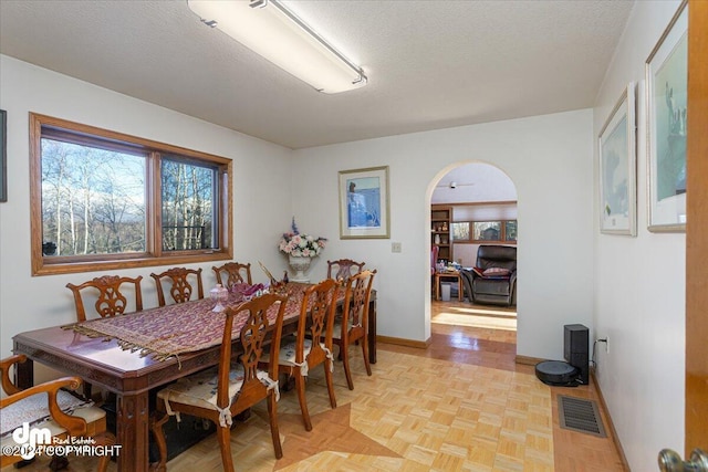 dining room with a textured ceiling and light parquet floors