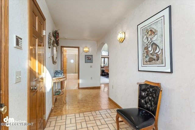 hall with light parquet floors and a textured ceiling