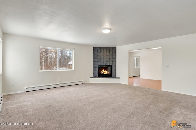 unfurnished living room featuring a baseboard heating unit, light carpet, and a fireplace