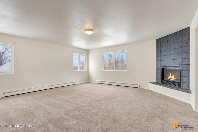 unfurnished living room featuring a baseboard radiator, a tiled fireplace, and carpet flooring