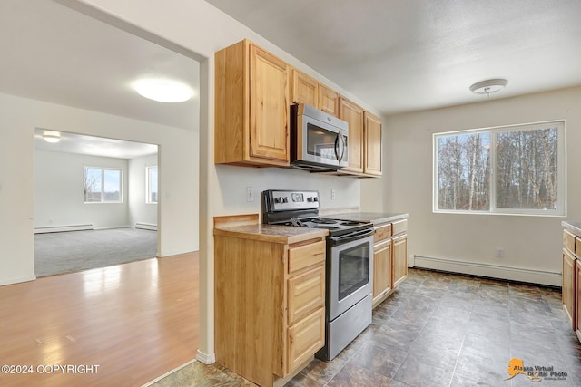 kitchen featuring baseboard heating, stainless steel appliances, and dark hardwood / wood-style flooring