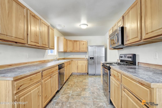 kitchen featuring stainless steel appliances, light brown cabinetry, and sink