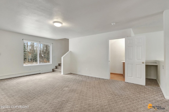 spare room with light carpet and baseboard heating