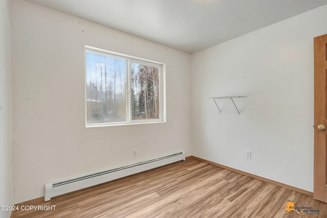 empty room with light hardwood / wood-style floors and baseboard heating