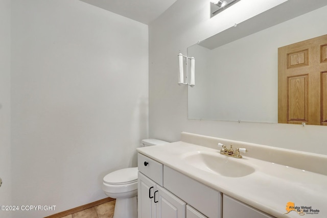 bathroom with toilet, vanity, and tile patterned floors