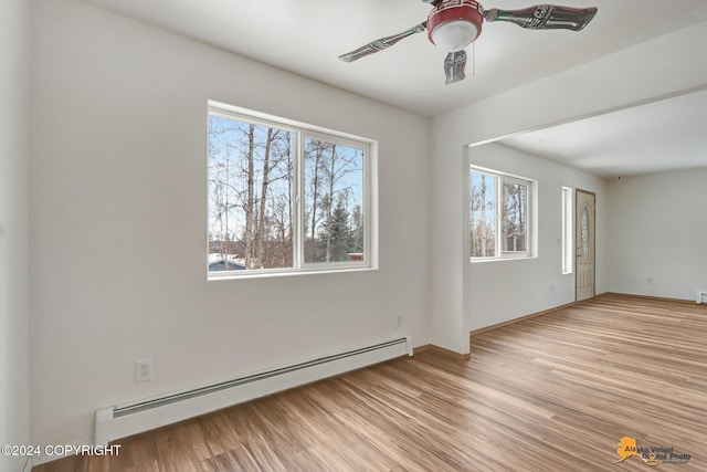 spare room featuring light hardwood / wood-style floors, a baseboard heating unit, and ceiling fan