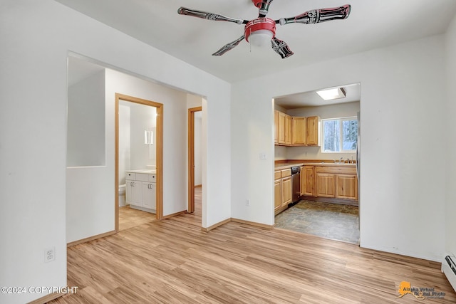 kitchen featuring light hardwood / wood-style floors, stainless steel dishwasher, a baseboard radiator, and light brown cabinets