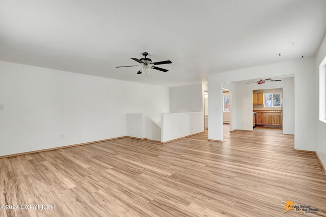 unfurnished living room featuring ceiling fan and light wood-type flooring