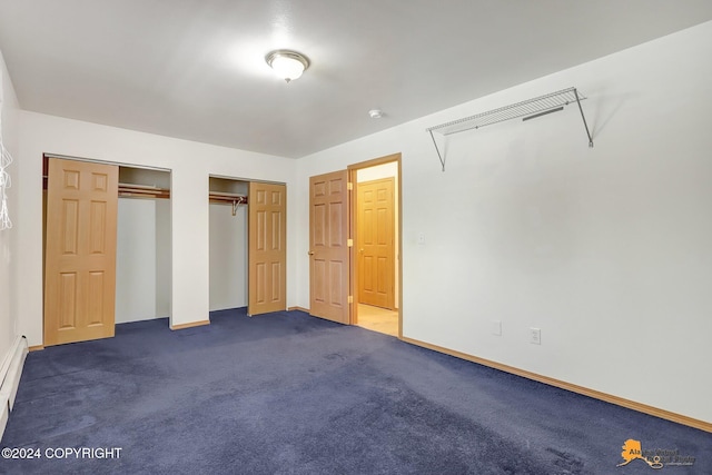 unfurnished bedroom with multiple closets and dark colored carpet