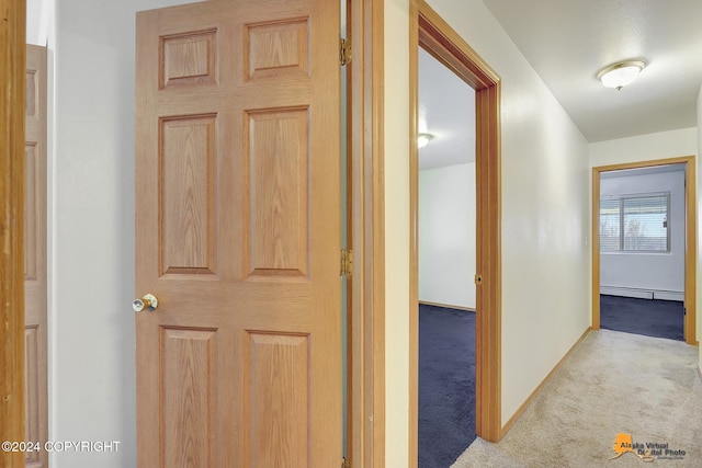 corridor featuring light carpet and baseboard heating